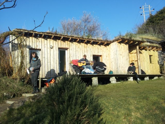 Timber clad caravan with decking and green roof.